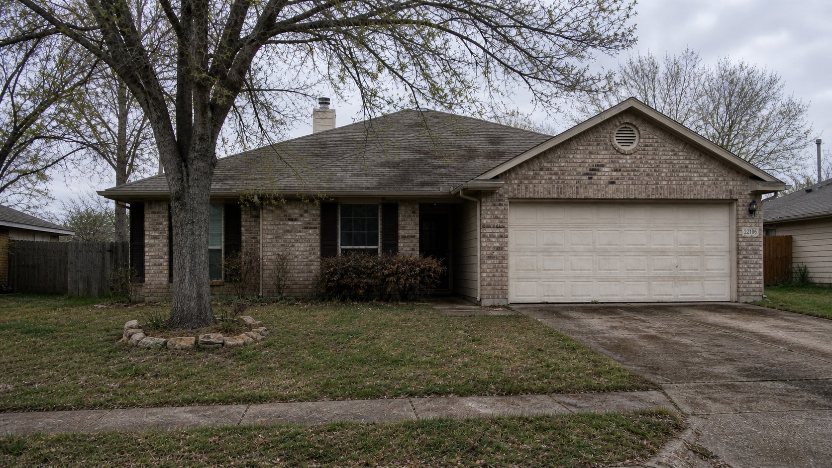North Houston home exterior before improvements — dead lawn, dirty driveway